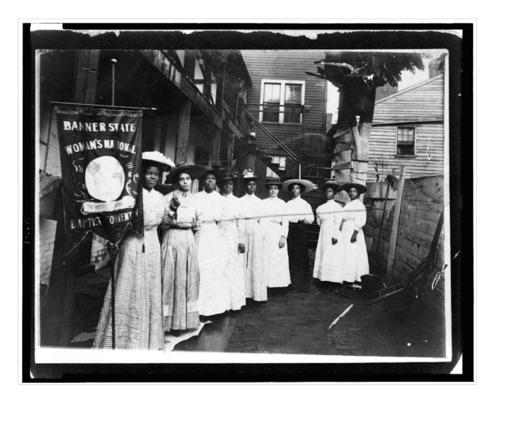 Women's Equality Day Image of National Baptist Convention banner being held up by 9 African-American women